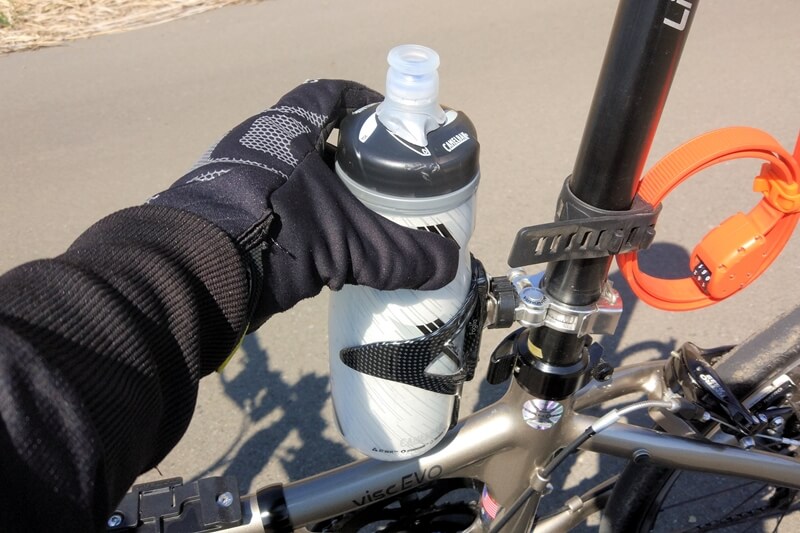 自転車ボトルをボトルケージから抜き取る