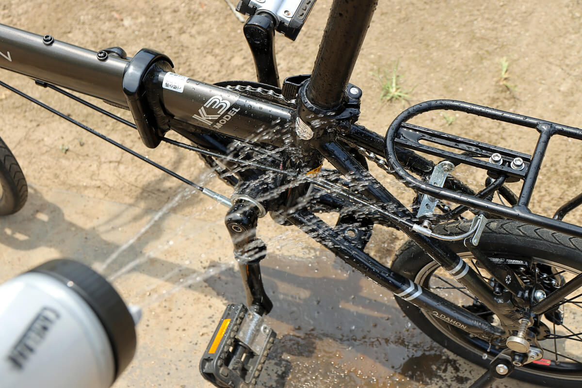 キャメルバックのシャワーボトルで自転車の泥を洗い流す